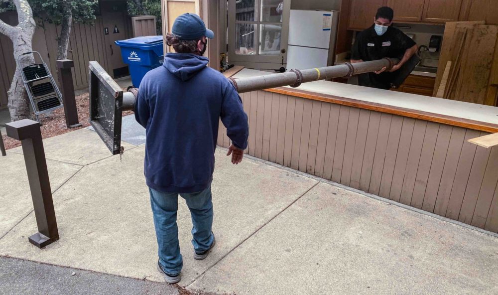 Workers removing old theater post